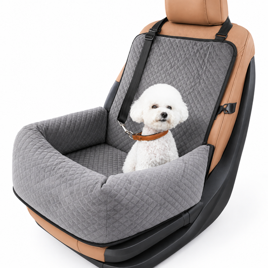 A small white dog sits inside a padded car seat cover designed for pets, shown on a clean white background. The cover is gray quilted fabric with black straps and trim, installed over a tan and black car seat.