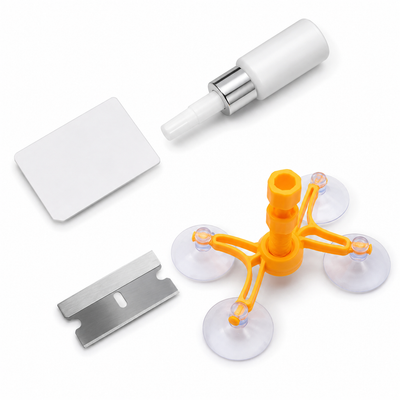 A 4-piece self-adhesive wall decal application kit on a white background, including a white adhesive bottle with a silver collar, a white squeegee, a silver metal razor blade, and an orange four-arm suction cup applicator.